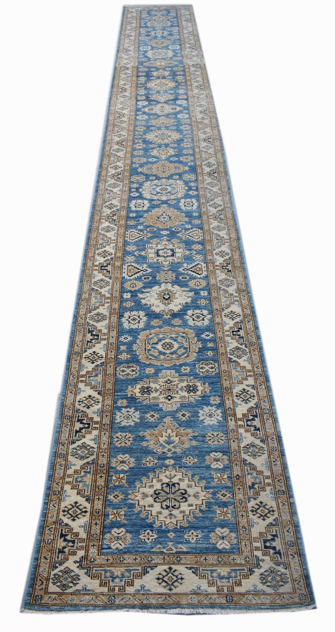 A long, handmade Afghan Super Kazakh runner rug featuring traditional geometric motifs in blue and tan.