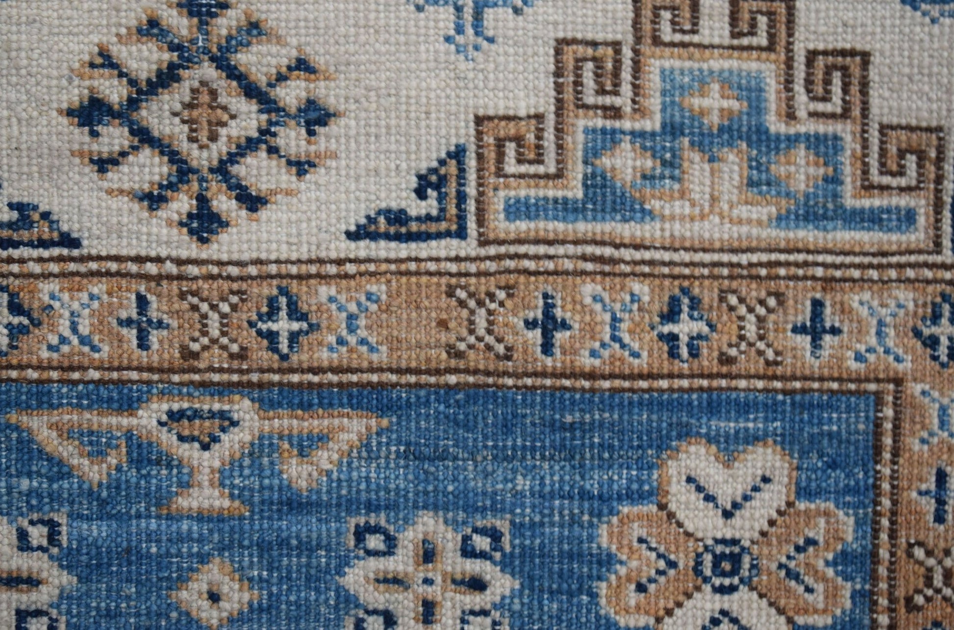 A handmade Afghan Super Kazakh runner featuring traditional blue and tan geometric motifs.