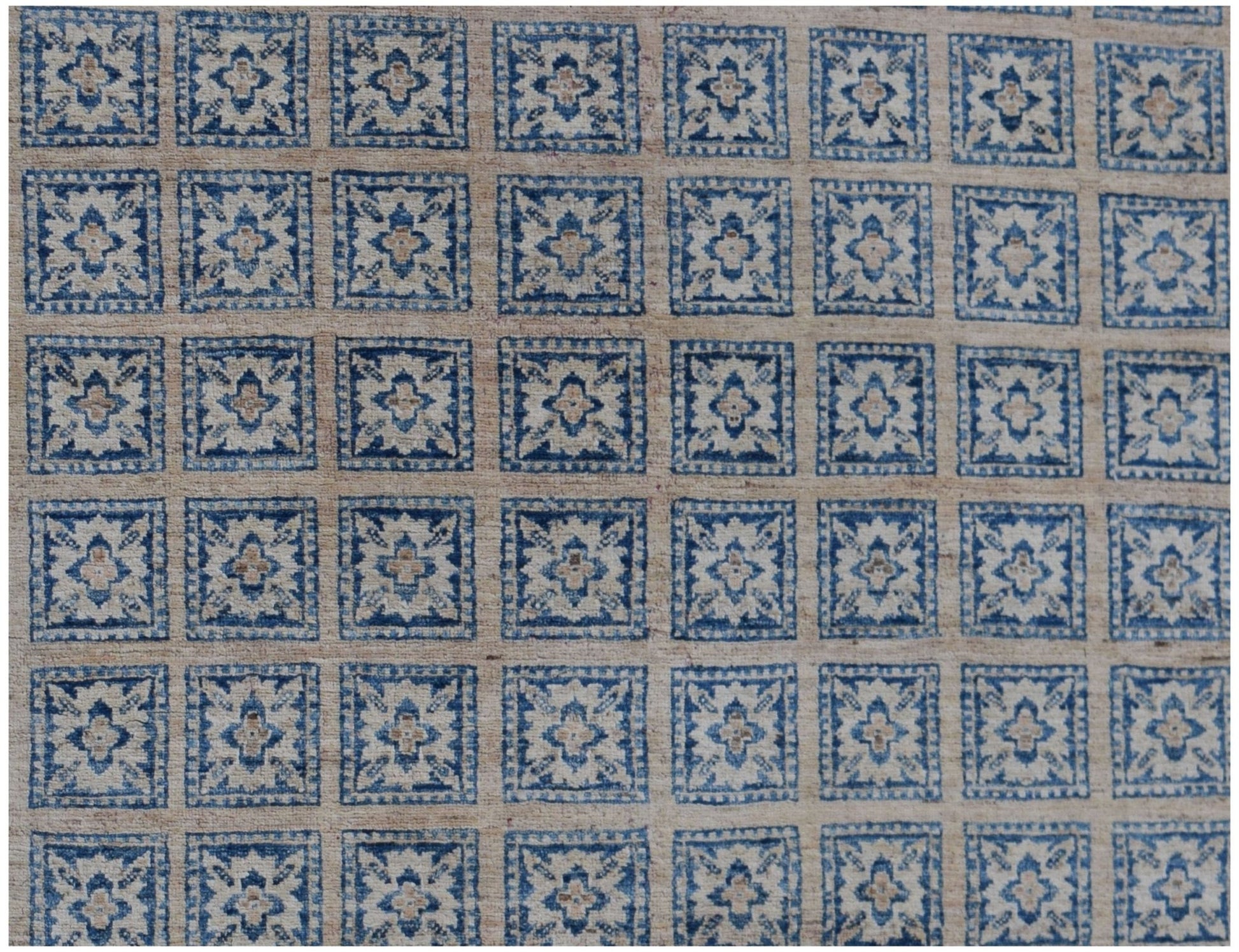 Handmade Afghan Chobi rug featuring a repeating grid of blue and beige floral square motifs.