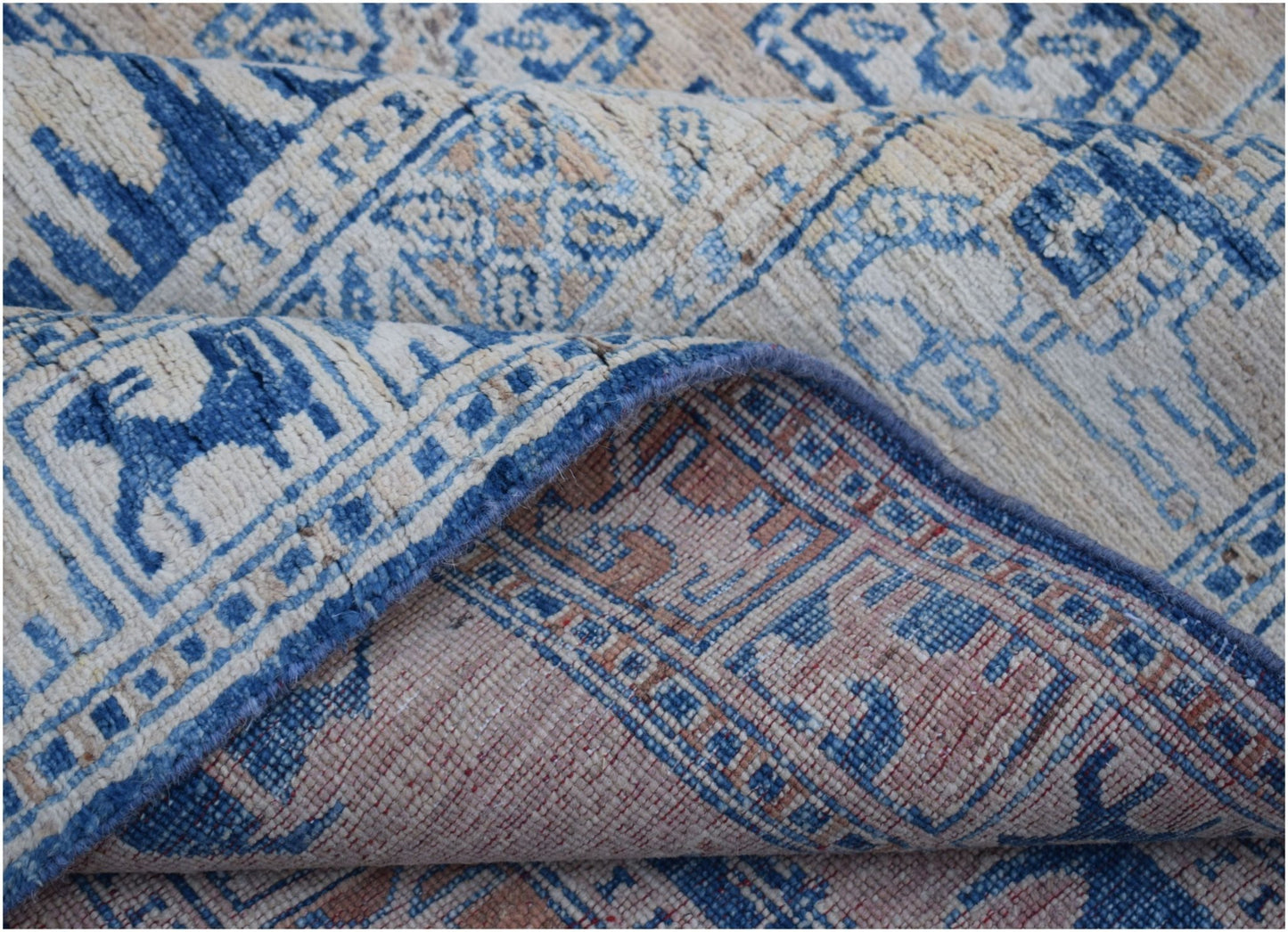 A handmade Afghan Chobi rug featuring a blue and beige geometric Pazyryk pattern.