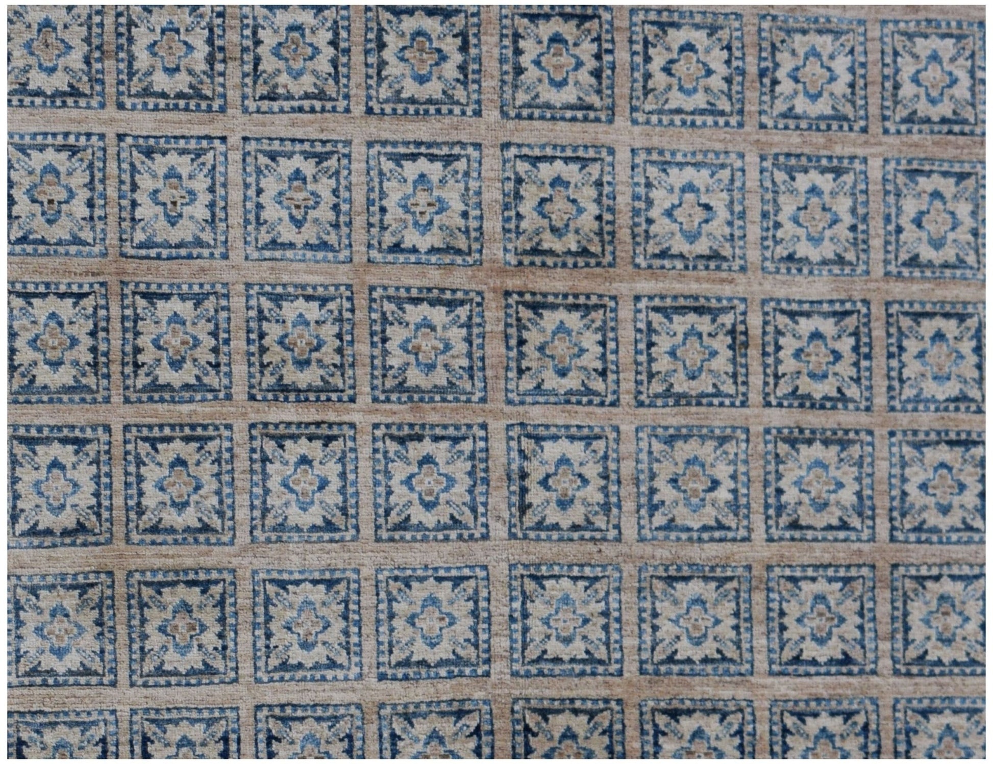 Handmade Afghan Chobi rug featuring a repeating grid of blue and beige floral square motifs.