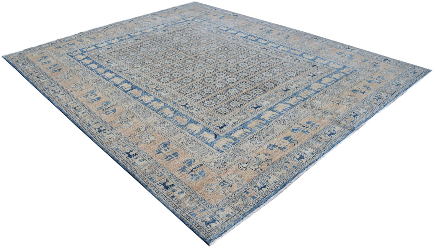 A handmade Afghan Chobi rug featuring a blue and beige Pazyryk pattern with animal motifs.