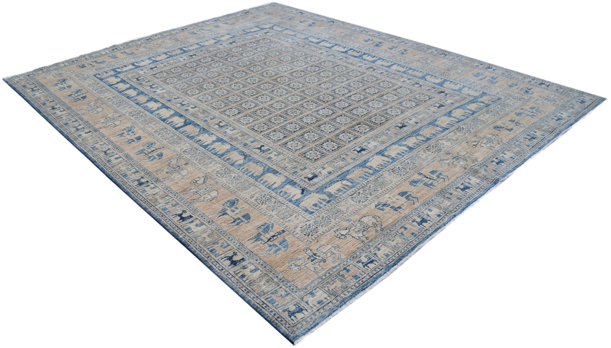 A handmade Afghan Chobi rug featuring a blue and beige Pazyryk pattern with animal motifs.