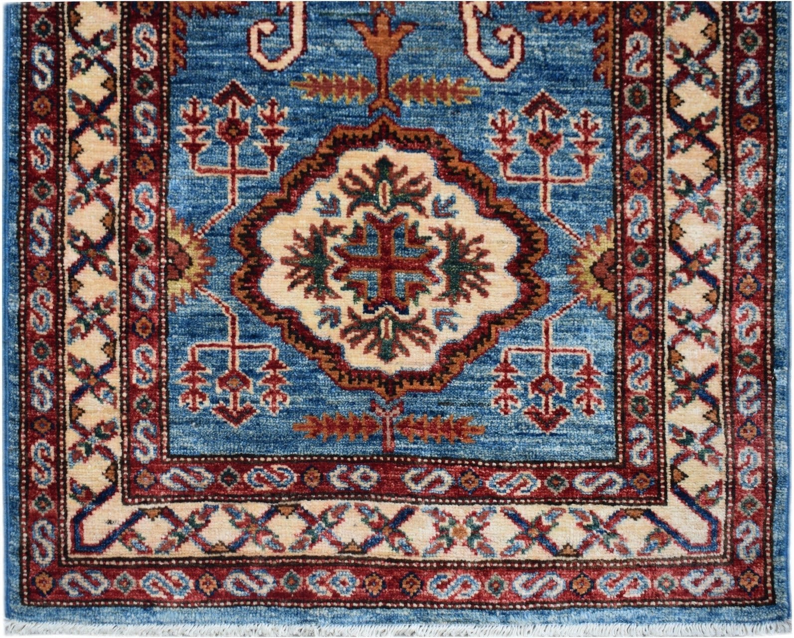 Handmade Afghan Super Kazakh runner featuring a central medallion on a blue wool field.
