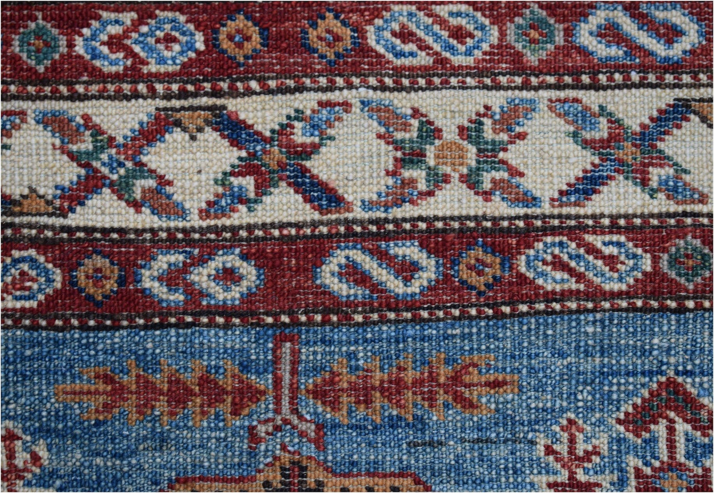 A close-up of an Afghan Super Kazakh runner featuring traditional geometric patterns in wool.