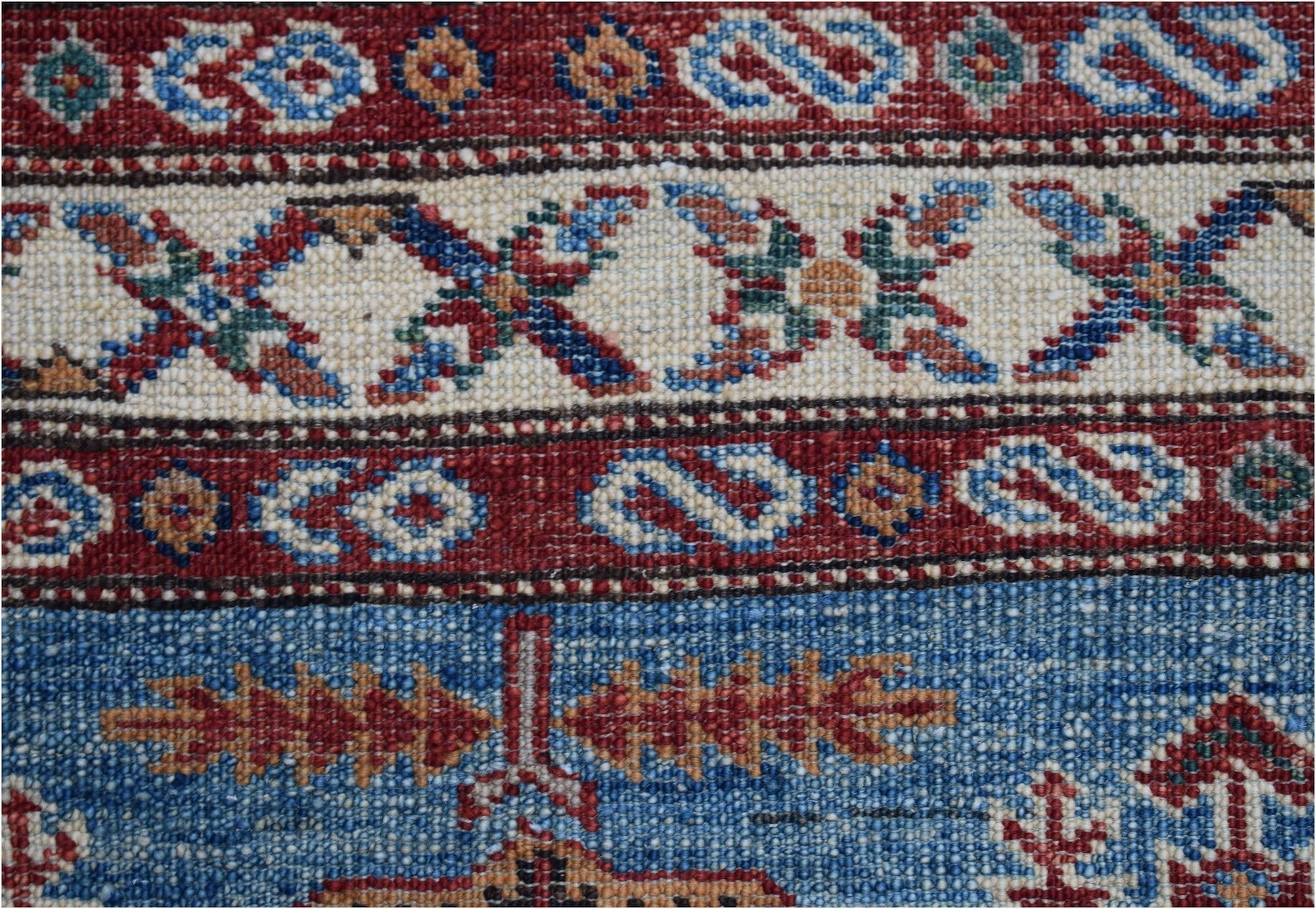 A close-up of an Afghan Super Kazakh runner featuring traditional geometric patterns in wool.
