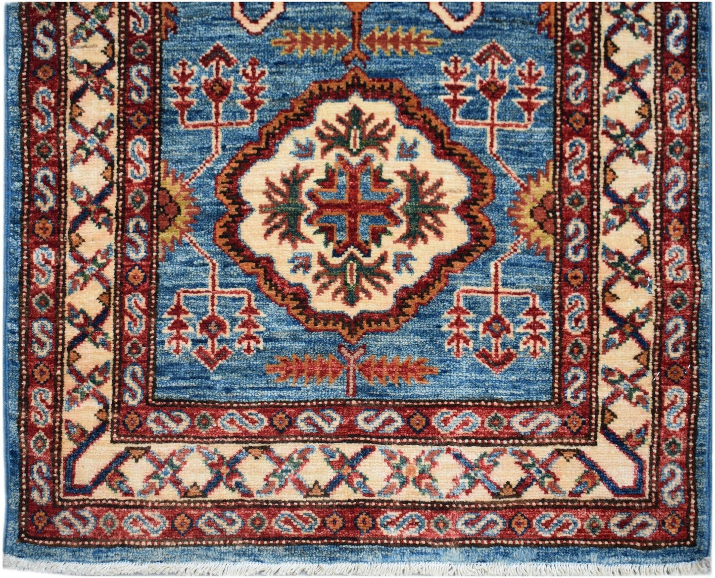Handmade Afghan Super Kazakh runner featuring a central medallion on a blue field with red borders.