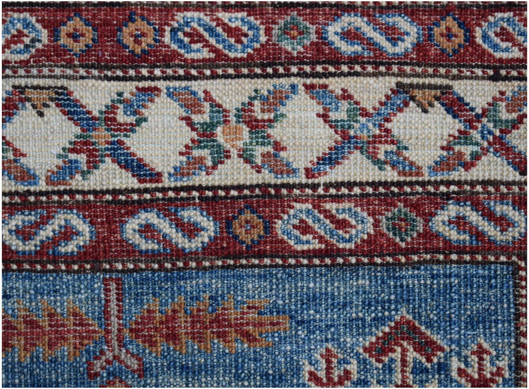 A close-up of an Afghan Super Kazakh runner featuring traditional geometric patterns in wool.
