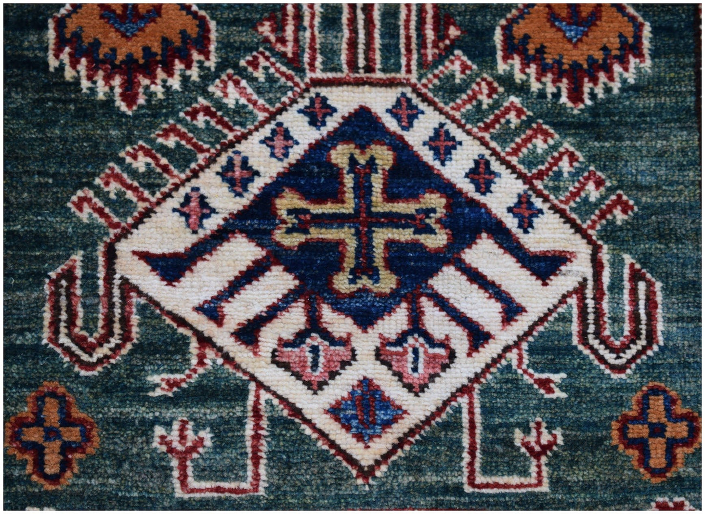 A handmade Afghan Super Kazakh runner featuring a central cross motif on a deep blue background.
