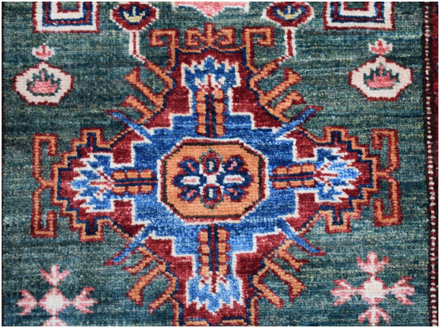 An Afghan Super Kazakh runner featuring a central geometric medallion in blue, red, and orange.
