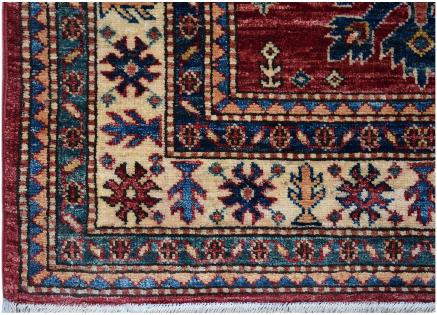 A handmade Afghan Super Kazakh runner featuring traditional geometric motifs in red, blue, and cream.