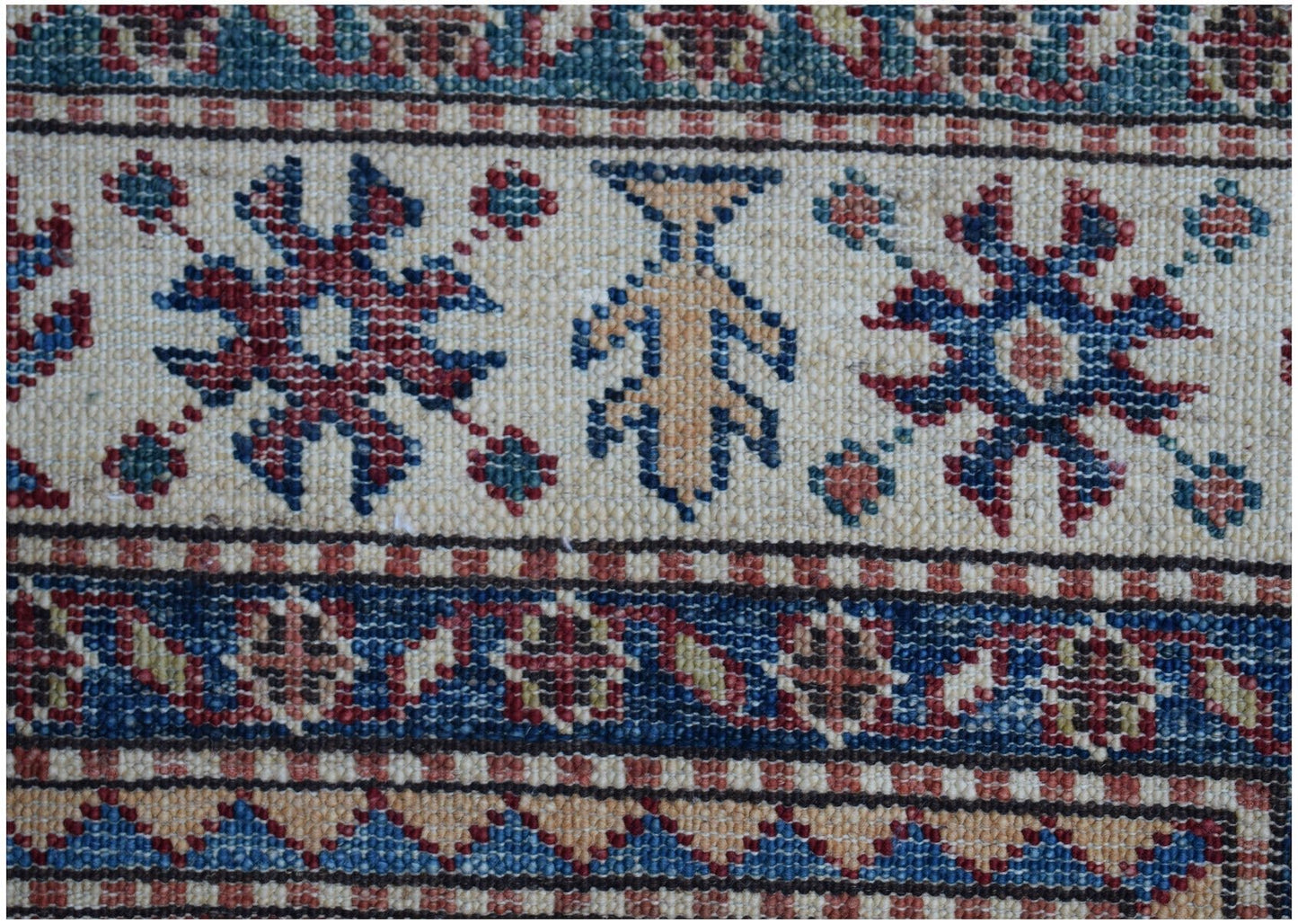 A close-up of an Afghan Super Kazakh runner featuring traditional geometric motifs in wool.
