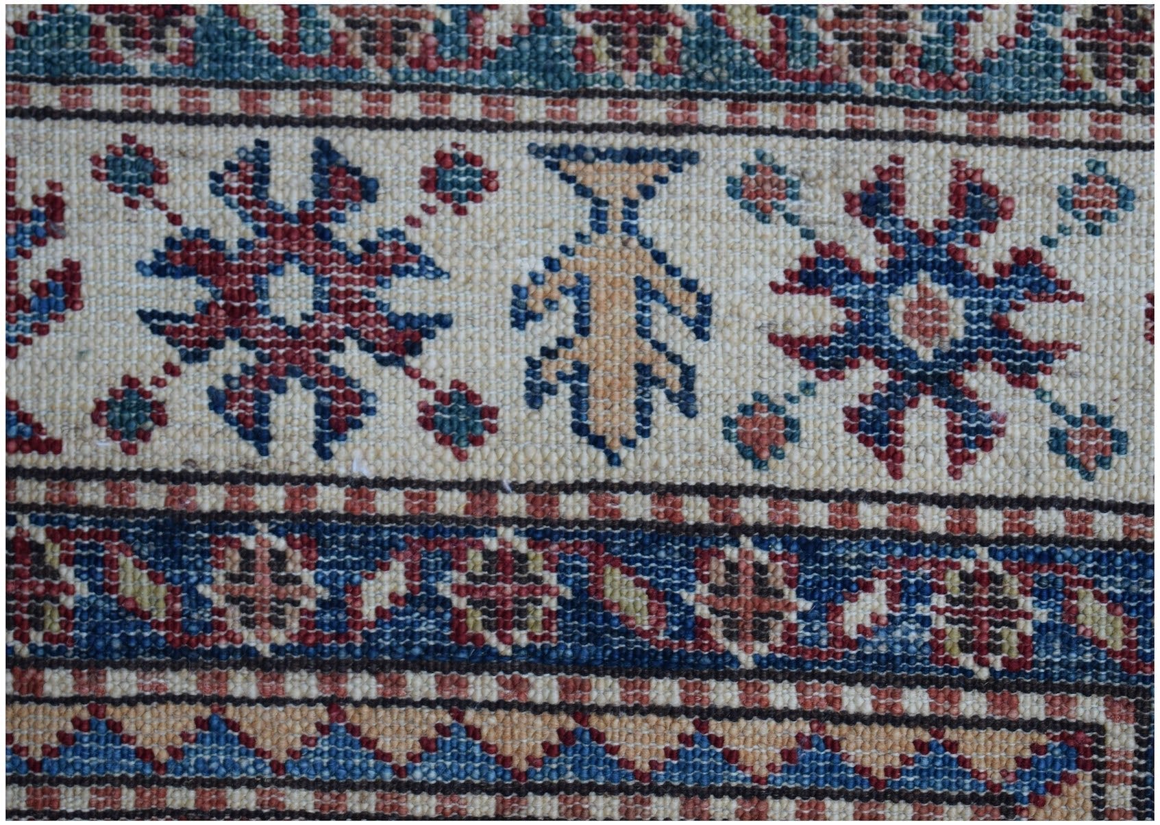 A close-up of an Afghan Super Kazakh runner featuring traditional geometric motifs in wool.