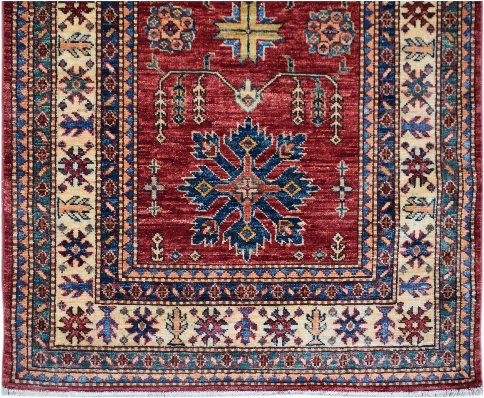 Handmade Afghan Super Kazakh runner rug featuring a red field with traditional blue floral motifs.