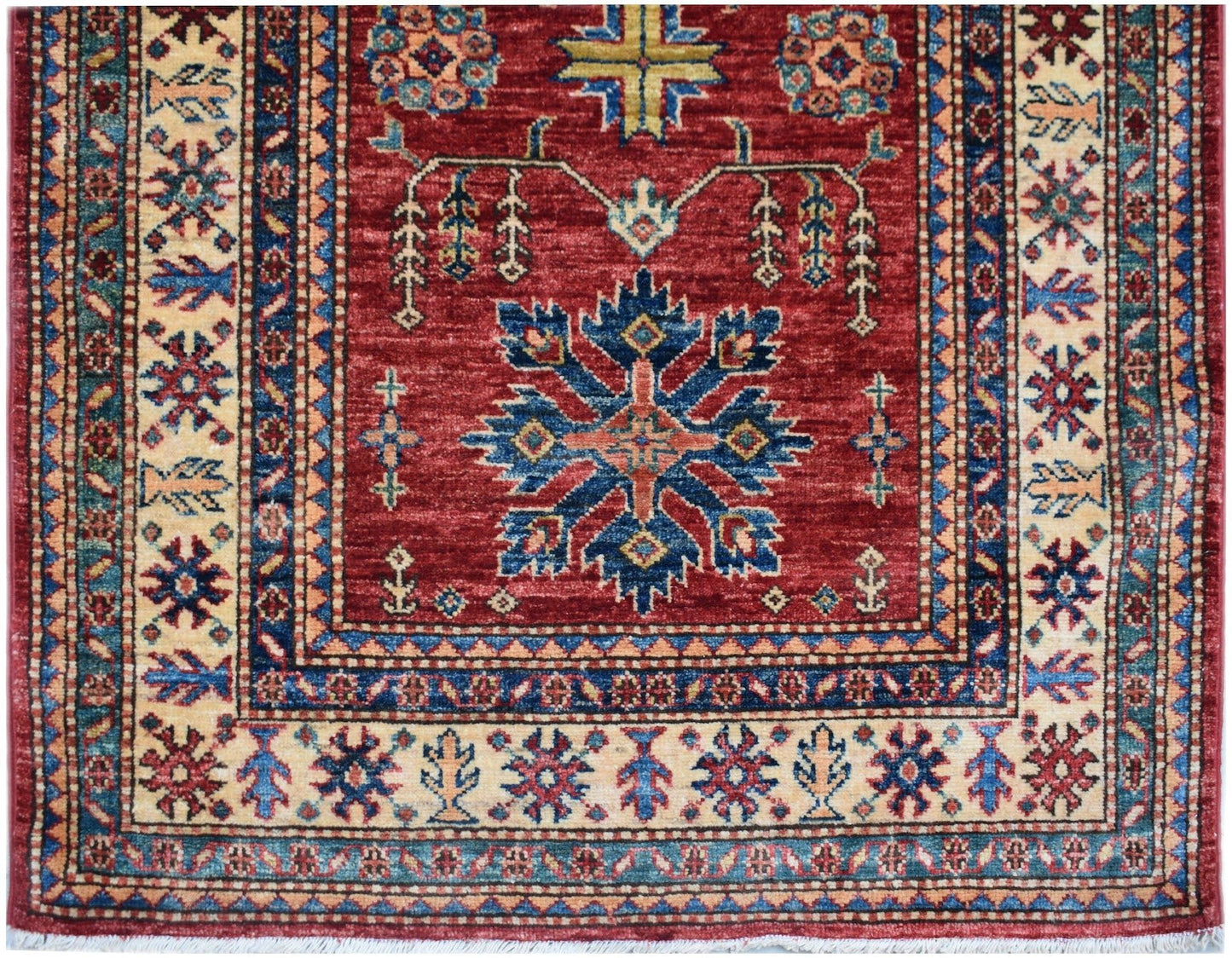 An Afghan Super Kazakh runner featuring a red field with a central blue geometric medallion.
