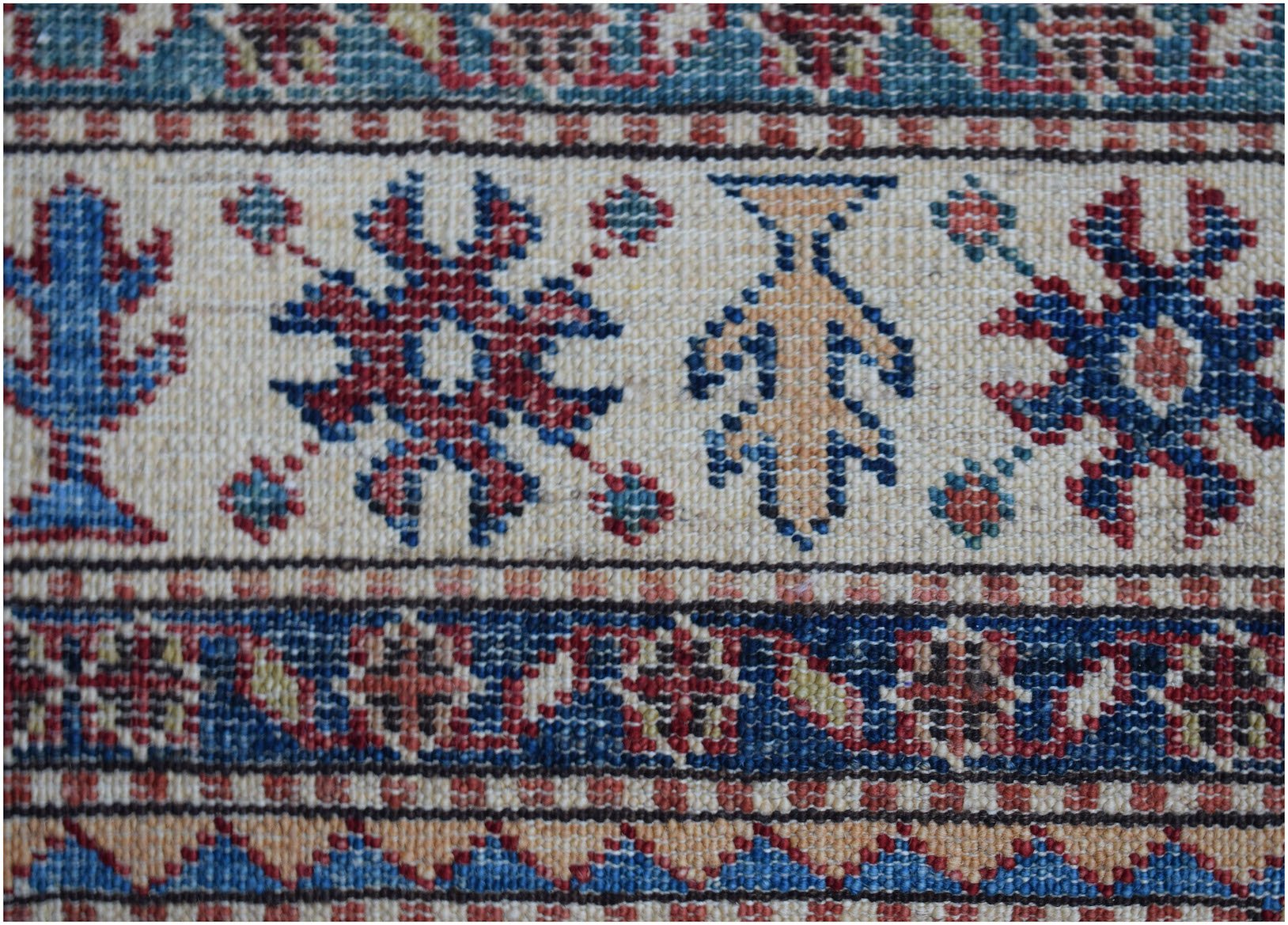 A close-up of an Afghan Super Kazakh runner featuring traditional geometric motifs in wool.