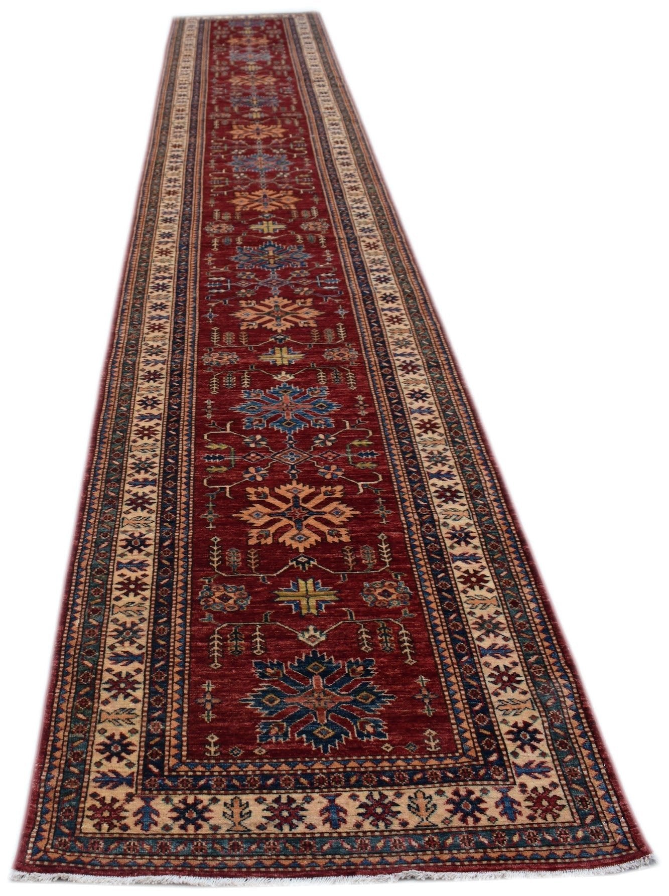 A long, handmade Afghan Super Kazakh runner rug featuring traditional geometric motifs in red.