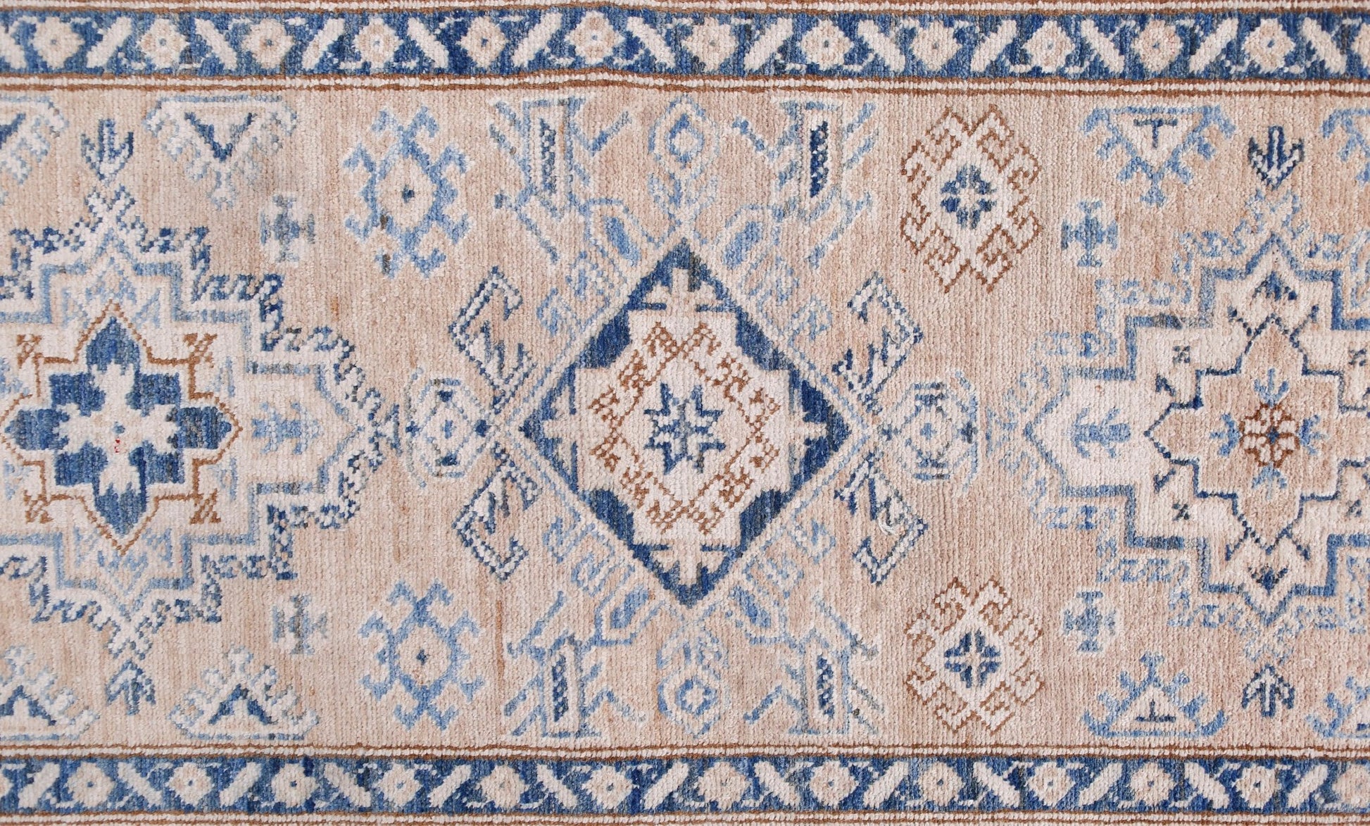 An Afghan Super Kazakh runner featuring traditional geometric motifs in blue and tan wool.