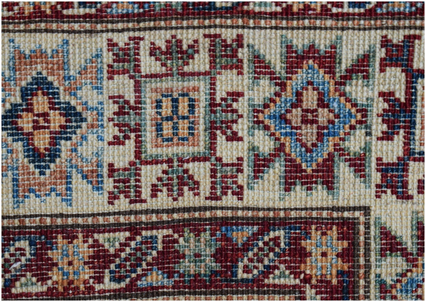 A close-up of an Afghan Super Kazakh runner featuring traditional geometric motifs in wool.