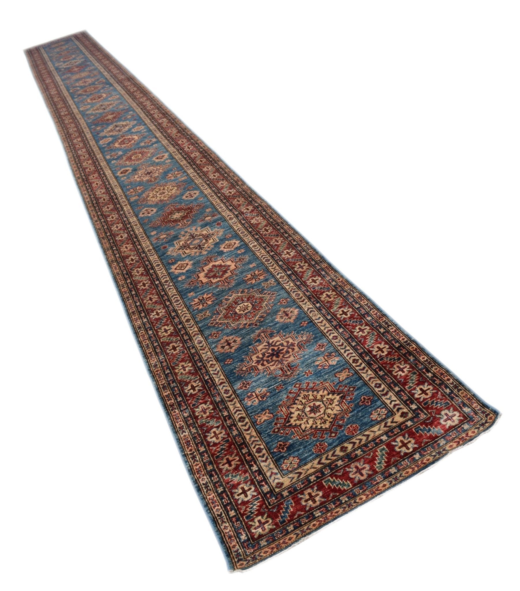 A long, handmade Afghan Super Kazakh runner rug featuring traditional geometric motifs in blue and red.