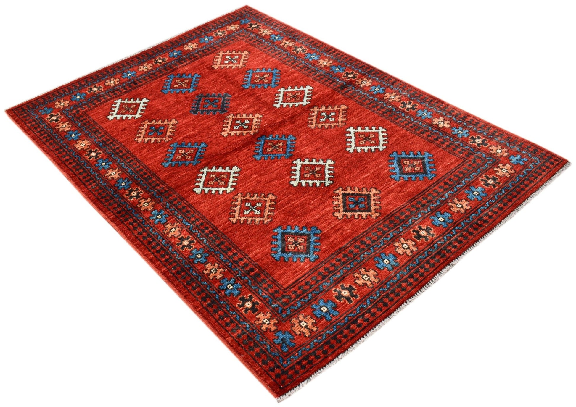 A handwoven Afghan Pashm rug featuring a red field with repeating geometric motifs.