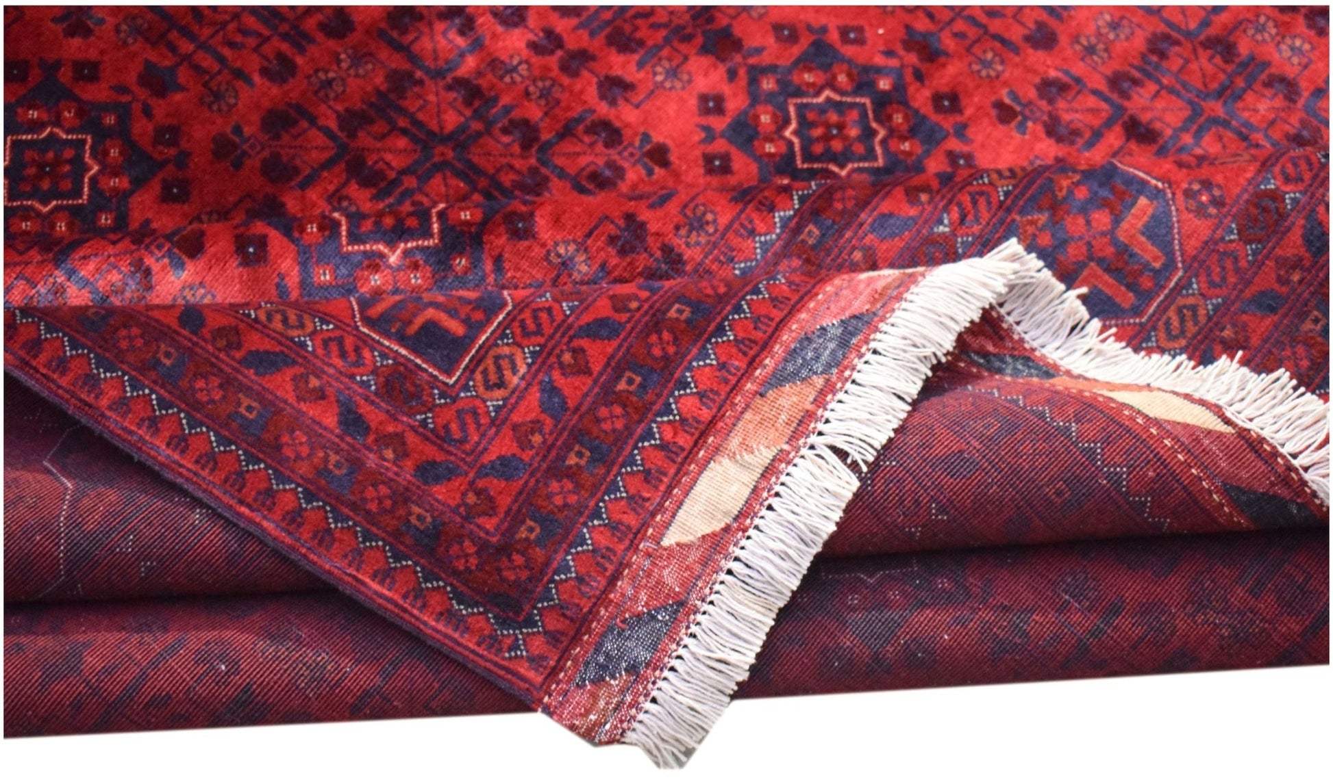 A handmade Afghan Biljik rug featuring deep red and blue geometric patterns with a fringed edge.