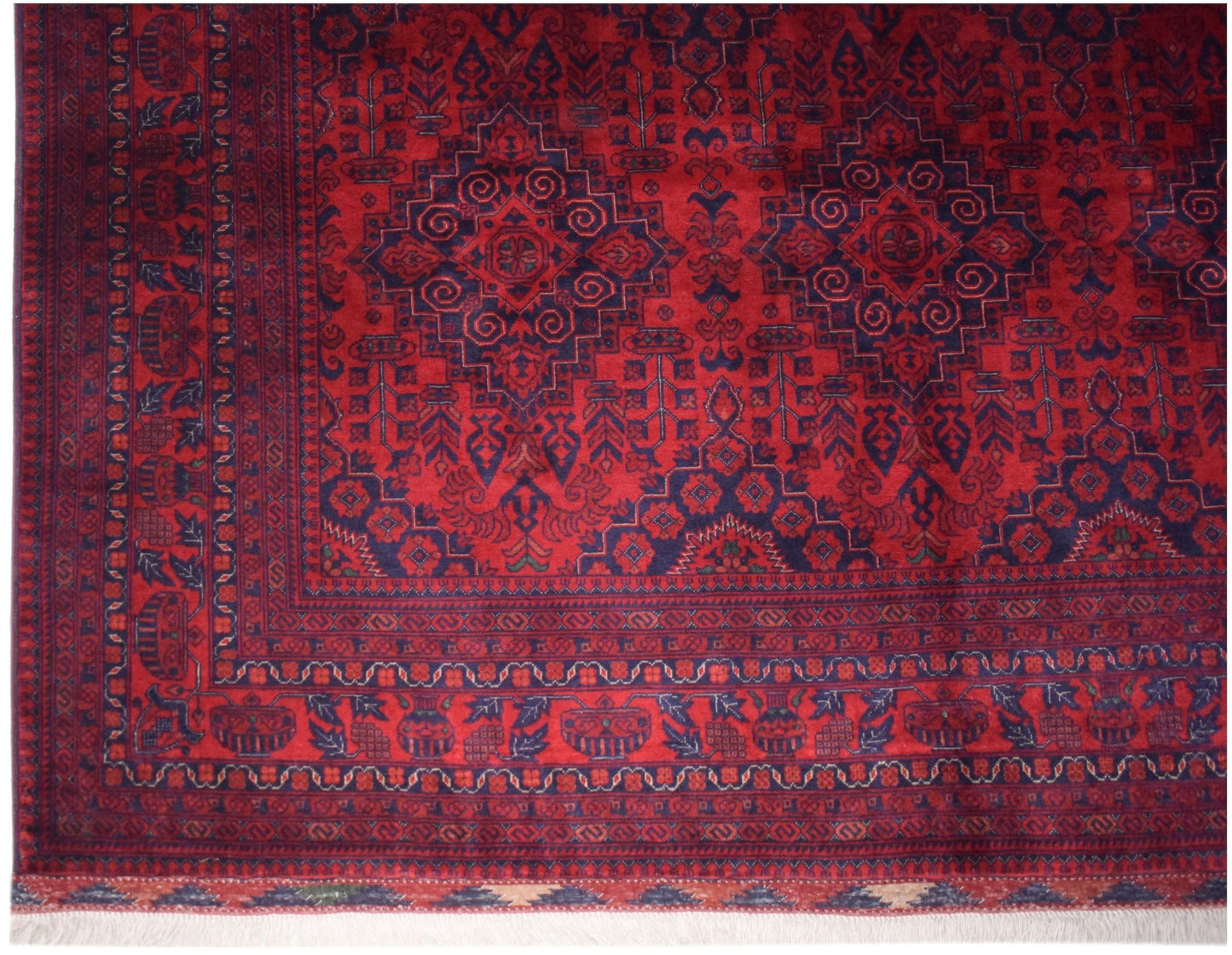 A handmade Afghan Biljik wool rug featuring intricate geometric patterns in deep red and blue.