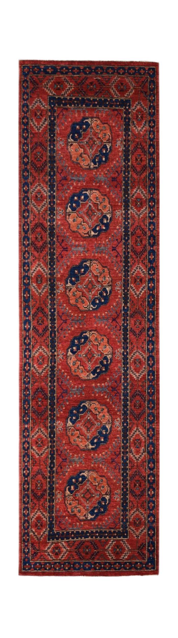 A handmade Afghan Chobi runner rug featuring a red field with repeating blue and orange medallions.