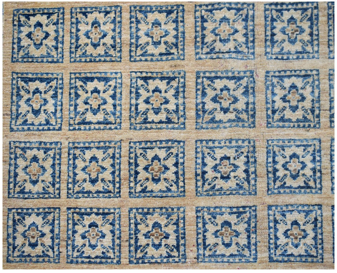 Handmade Afghan Chobi rug featuring a repeating blue and beige geometric floral square pattern.