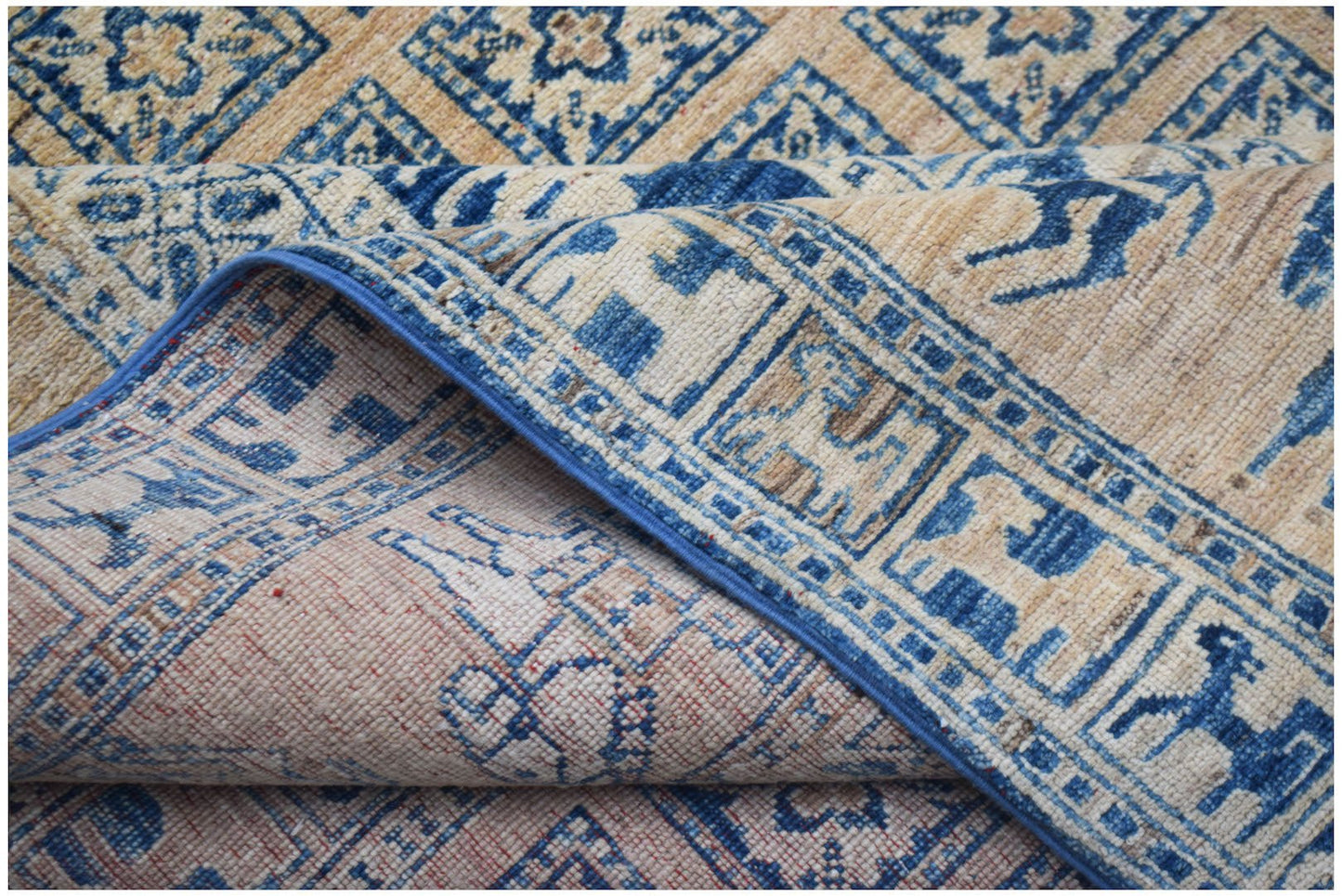 A handmade Afghan Chobi rug featuring a blue and beige Pazyryk-inspired geometric animal pattern.