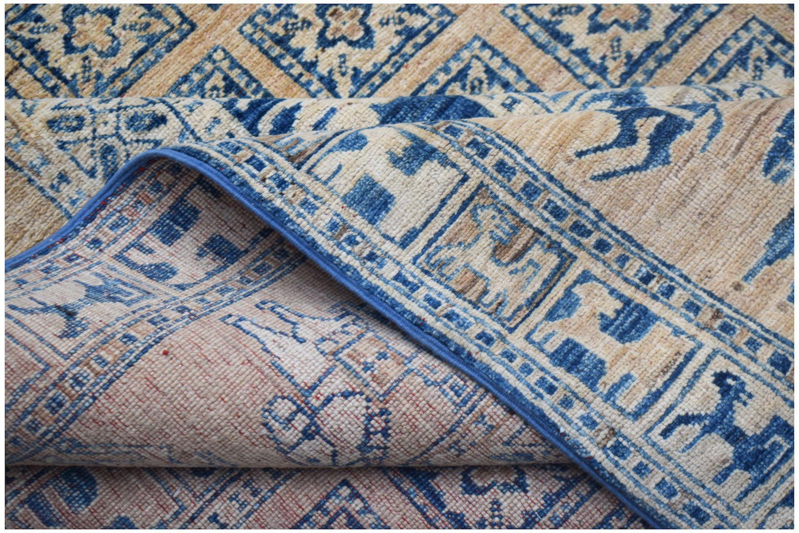 A handmade Afghan Chobi rug featuring a blue and beige Pazyryk-inspired geometric animal pattern.