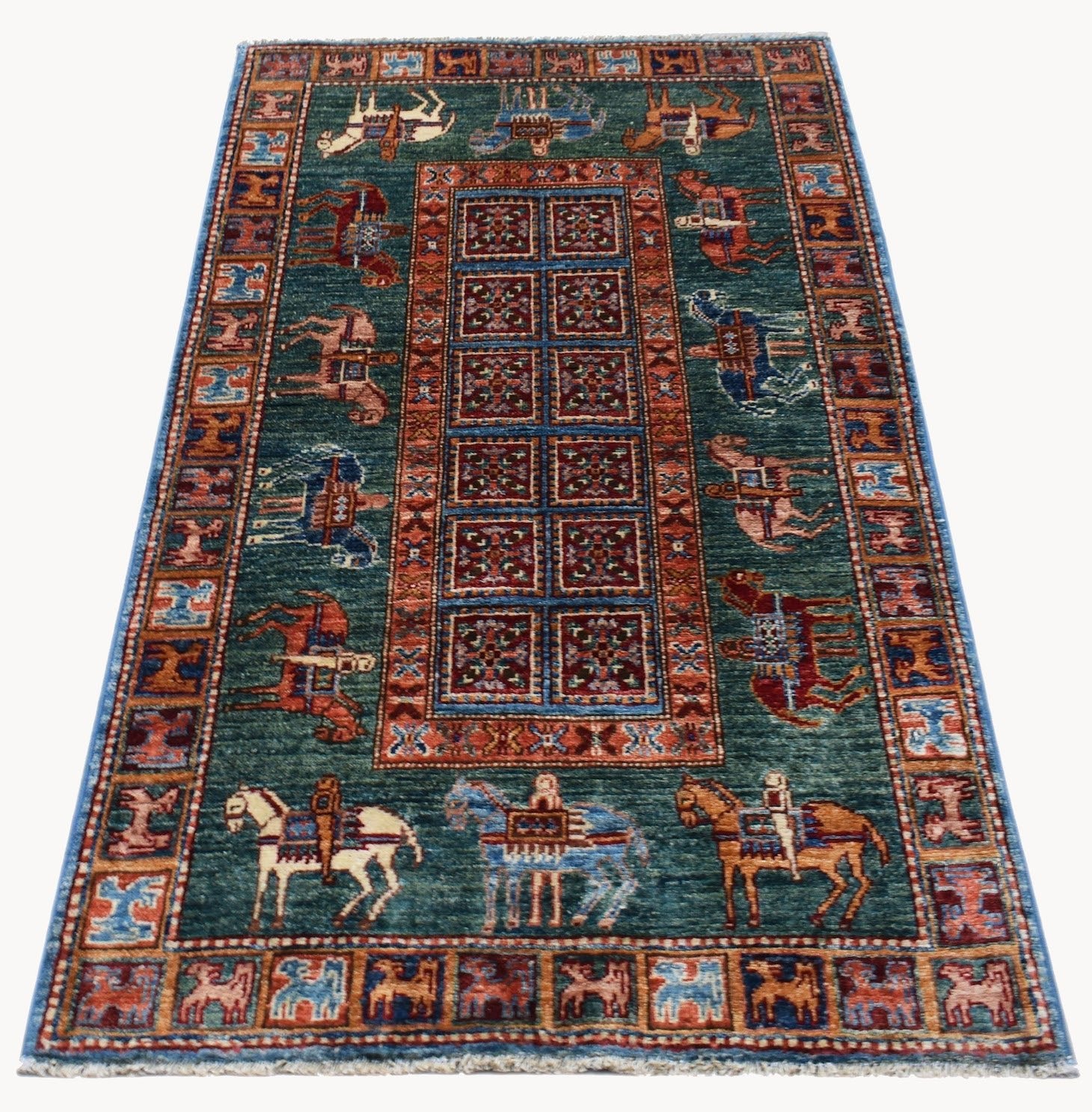 A rectangular Afghan Chobi rug featuring a central grid of floral motifs surrounded by horse riders.