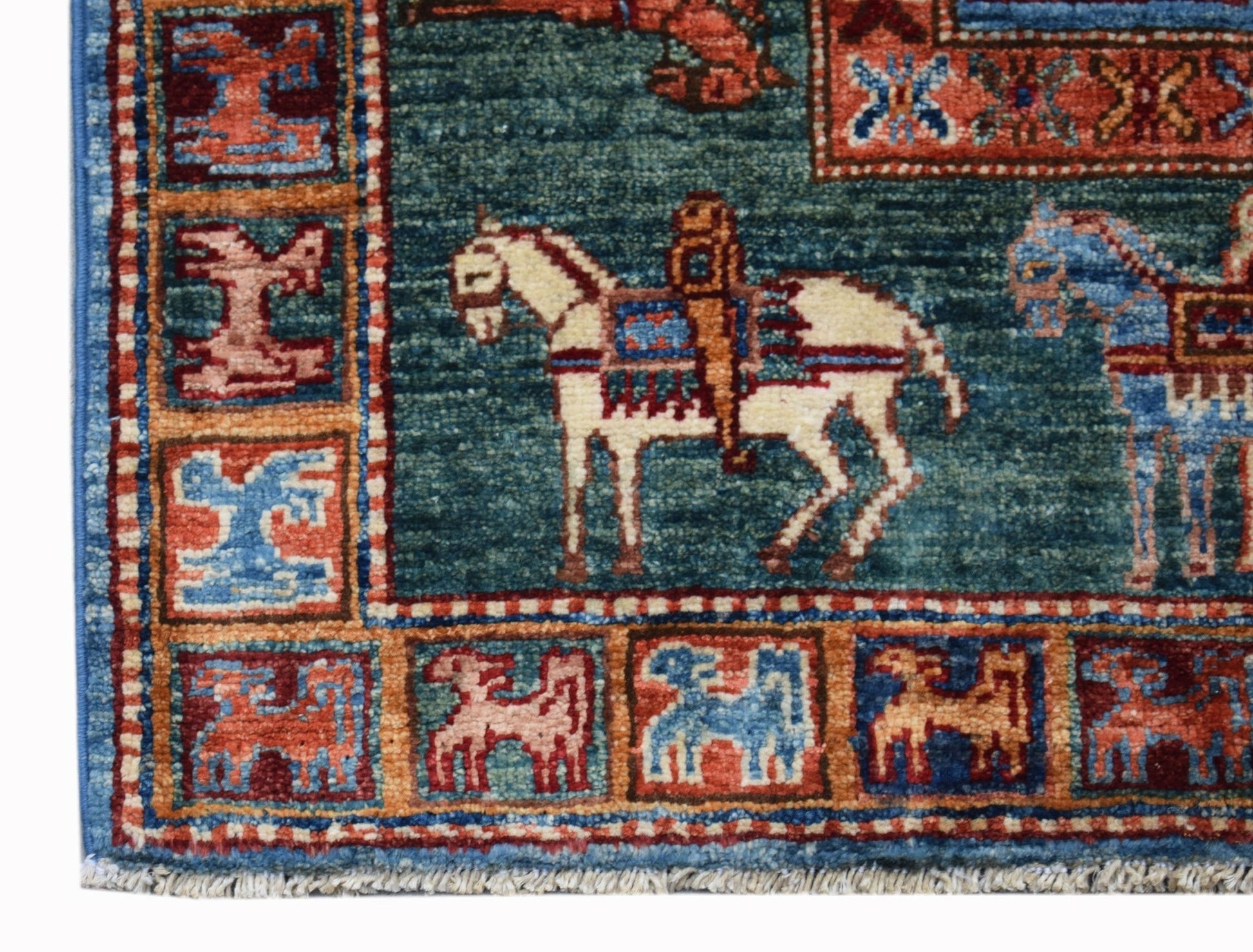 A handmade Afghan Chobi rug featuring a teal field with horse motifs and a patterned border.