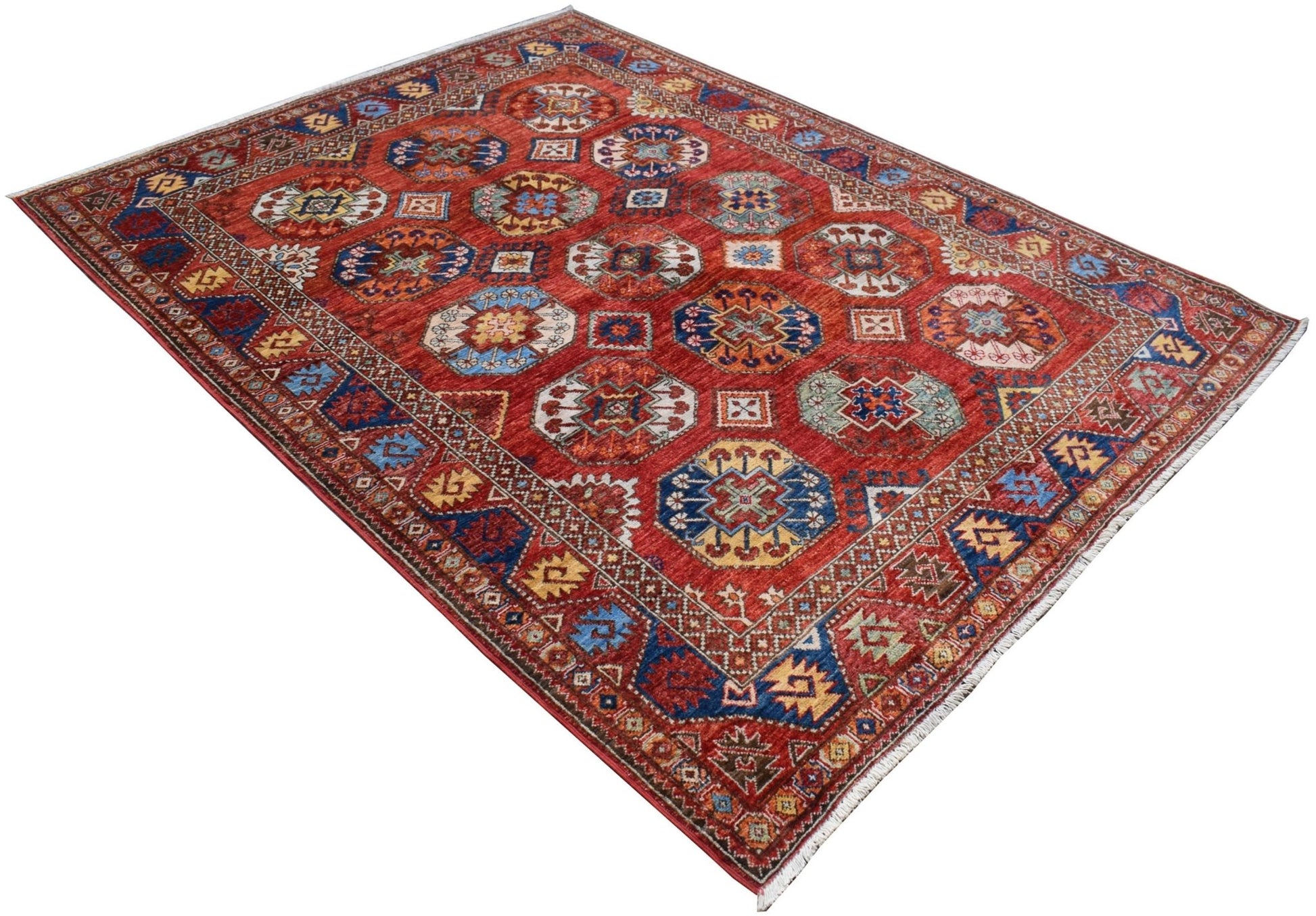 A handmade Afghan Chobi rug featuring a red field with repeating geometric octagonal motifs.