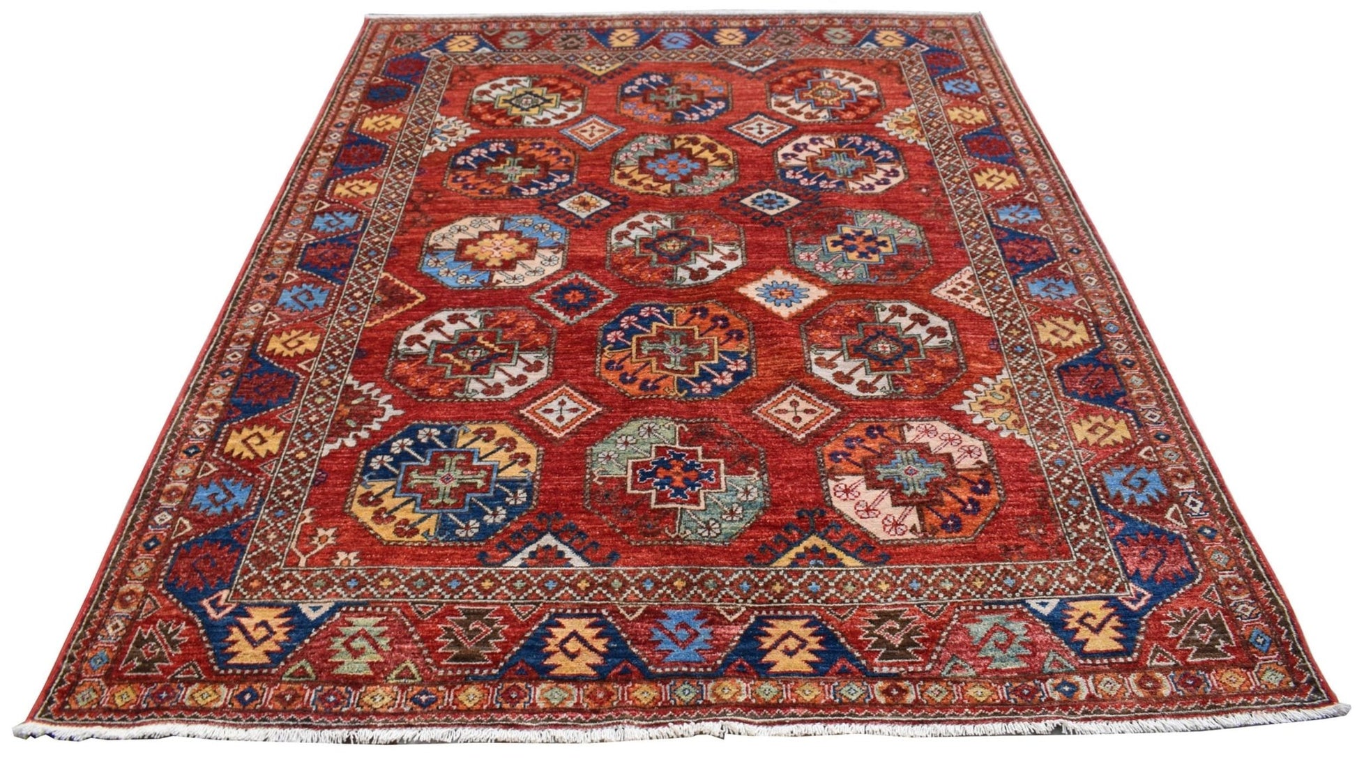 A handmade Afghan Chobi rug featuring a red field with repeating geometric octagonal motifs.