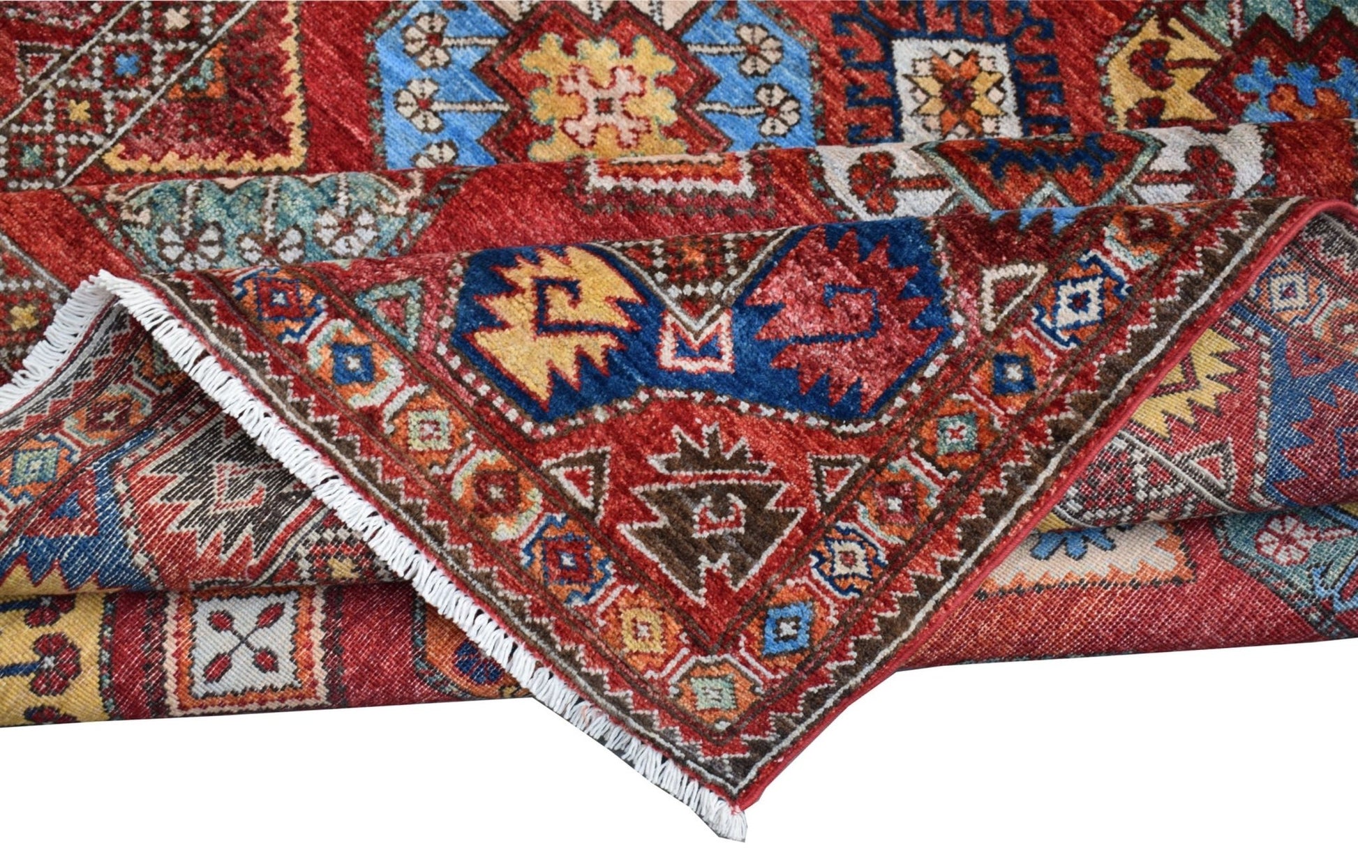 A handmade Afghan Chobi rug featuring a traditional geometric pattern in red, blue, and yellow.