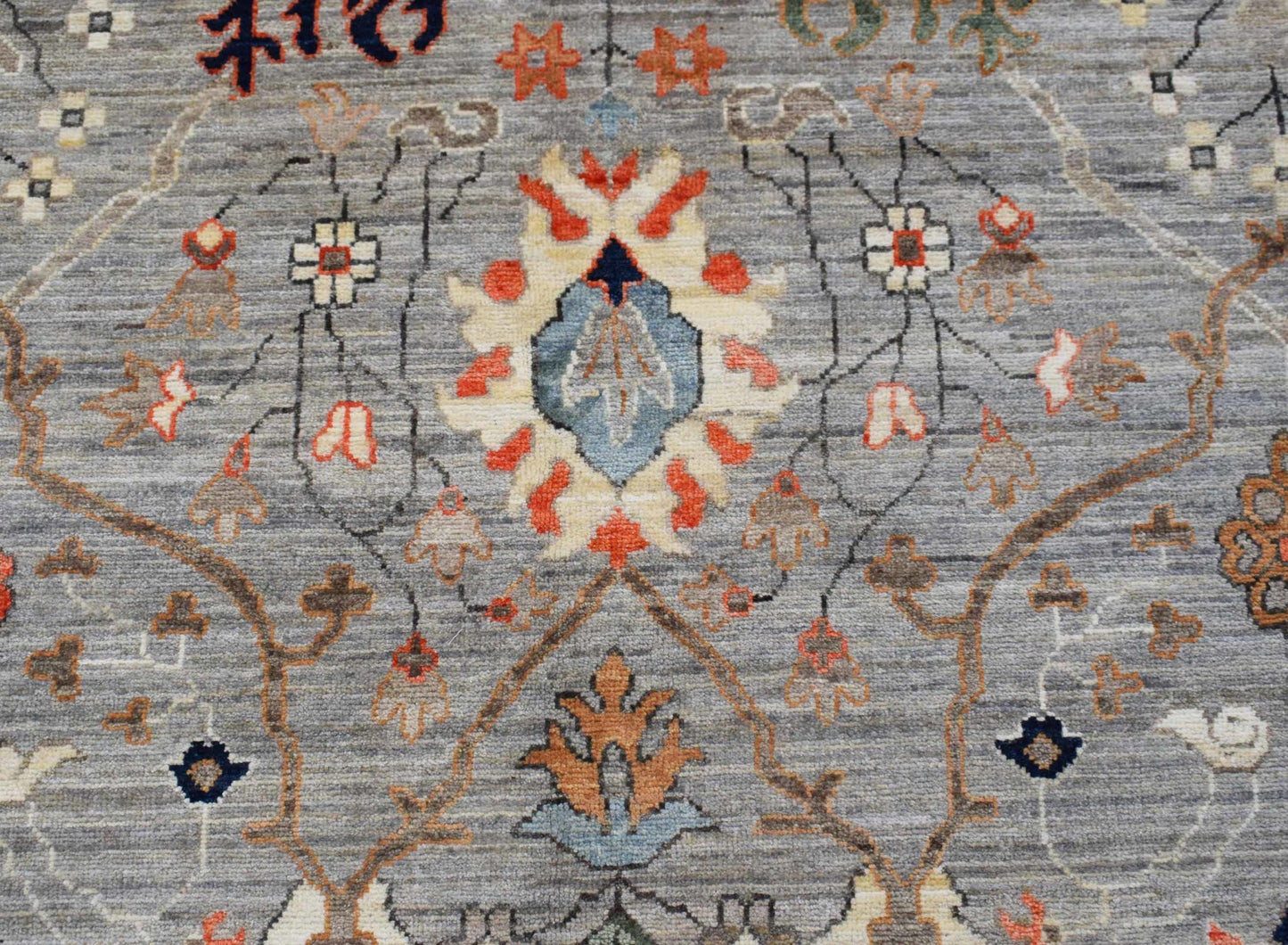 A handwoven Afghan Chobi rug featuring a traditional floral pattern in muted earth tones.