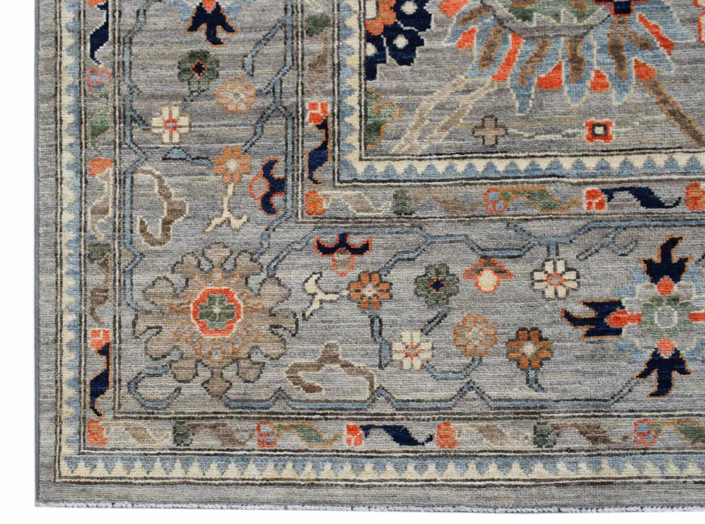 A handwoven Afghan Chobi rug featuring a traditional floral pattern in muted earth tones.