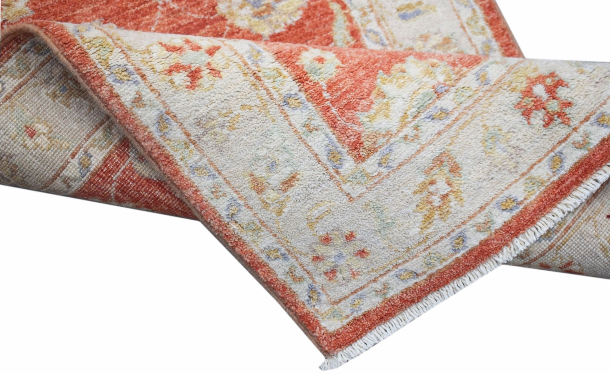 A handwoven Afghan Chobi runner featuring a traditional floral pattern in rust and cream tones.