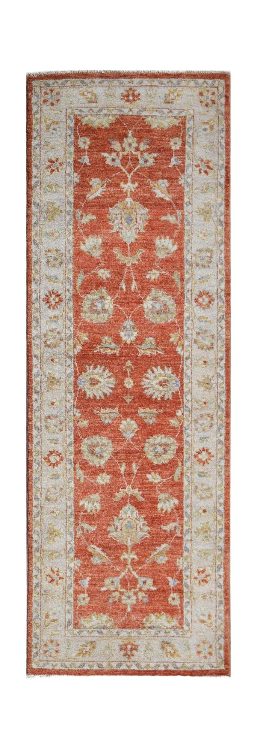 A handmade Afghan Chobi runner rug featuring a traditional floral pattern in rust and cream tones.