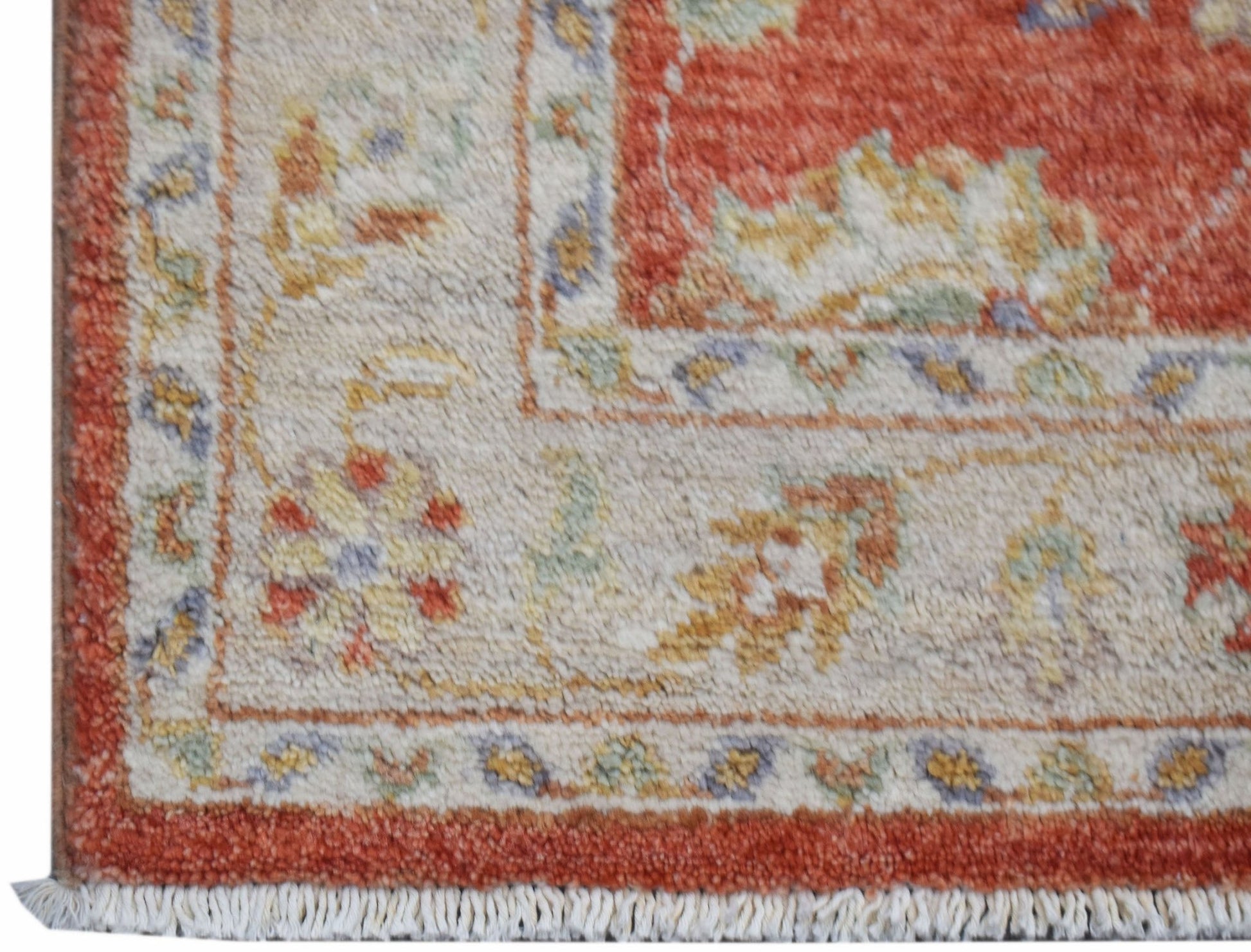A close-up of an Afghan Chobi runner featuring a traditional floral pattern in red and beige tones.