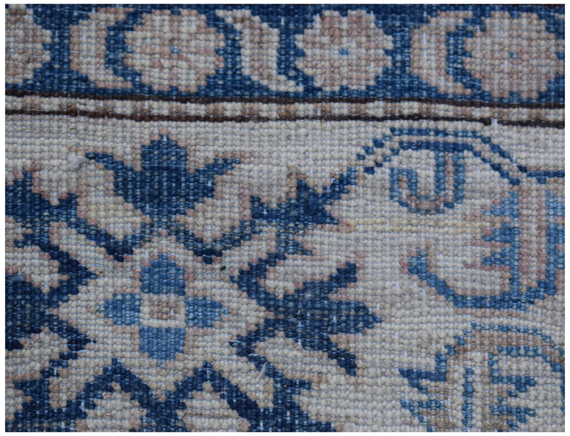 A close-up of an Afghan Super Kazakh rug featuring traditional blue and cream geometric patterns.