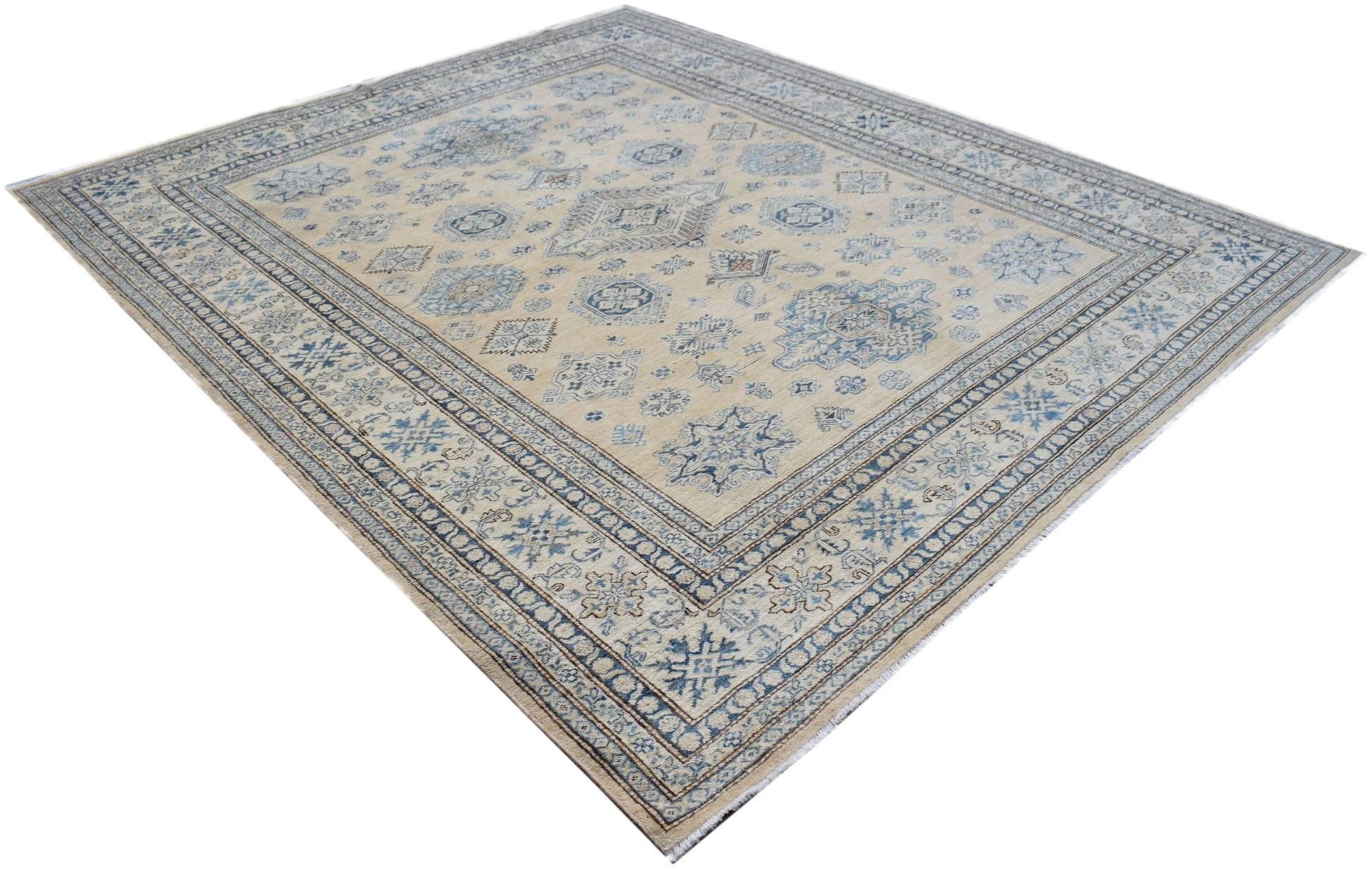 Handmade Afghan Super Kazakh rug featuring traditional blue geometric motifs on a beige field.