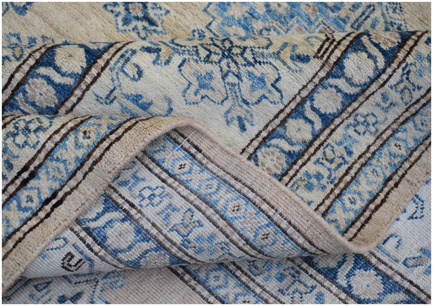 A handmade Afghan Super Kazakh rug featuring traditional blue and cream floral patterns.