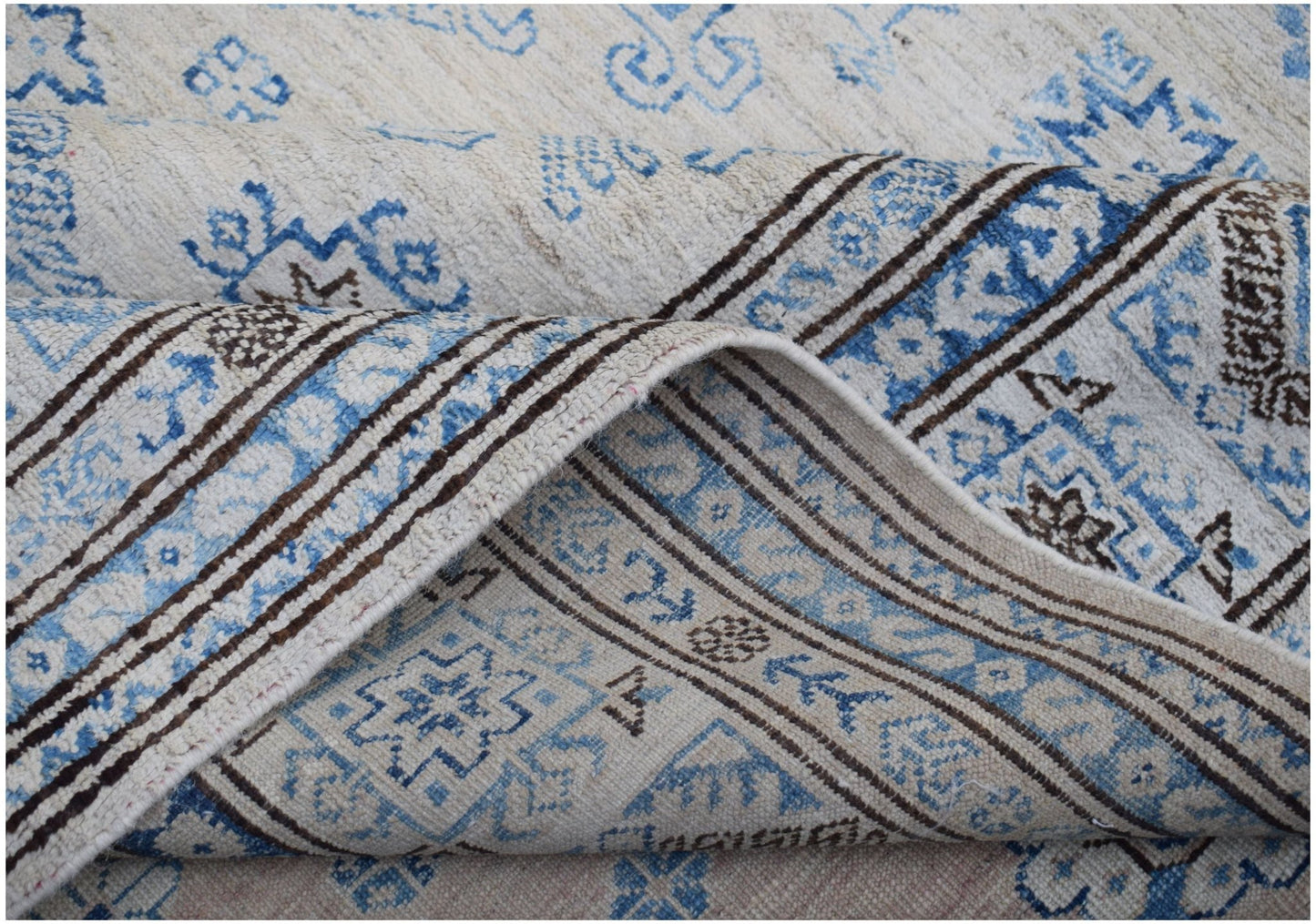 A handmade Afghan Super Kazakh rug featuring traditional blue and brown geometric motifs.