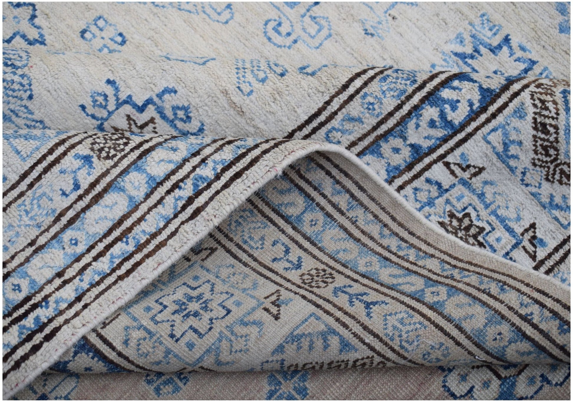 A handmade Afghan Super Kazakh rug featuring traditional blue and brown geometric motifs.