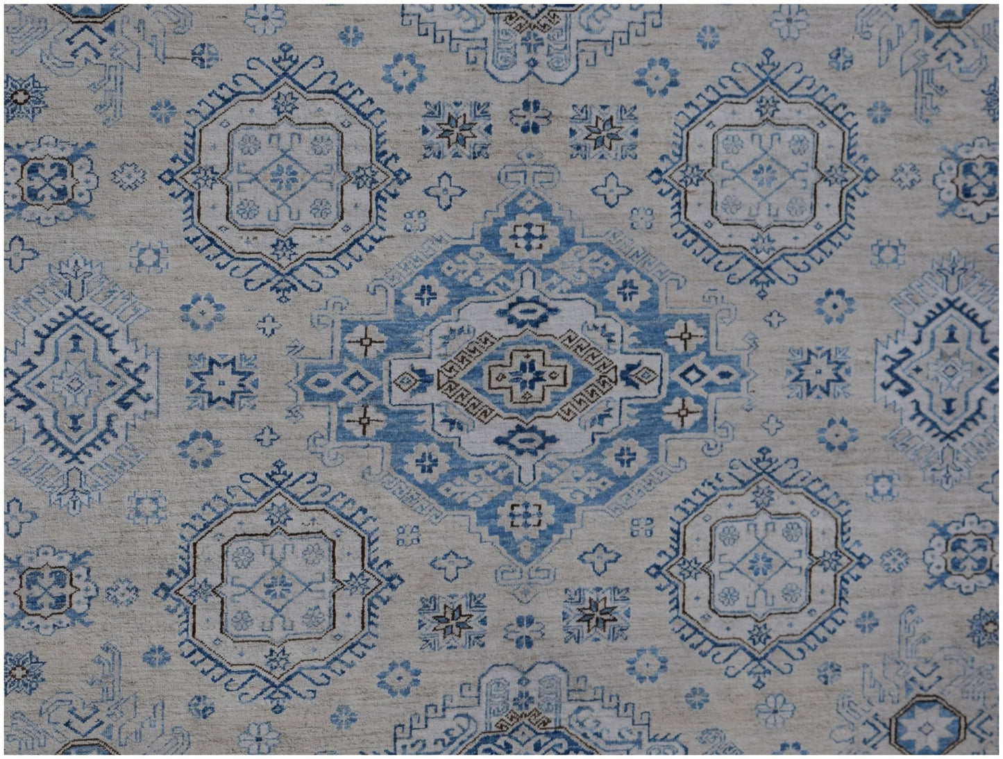 Handmade Afghan Super Kazakh rug featuring traditional blue and beige geometric medallion patterns.