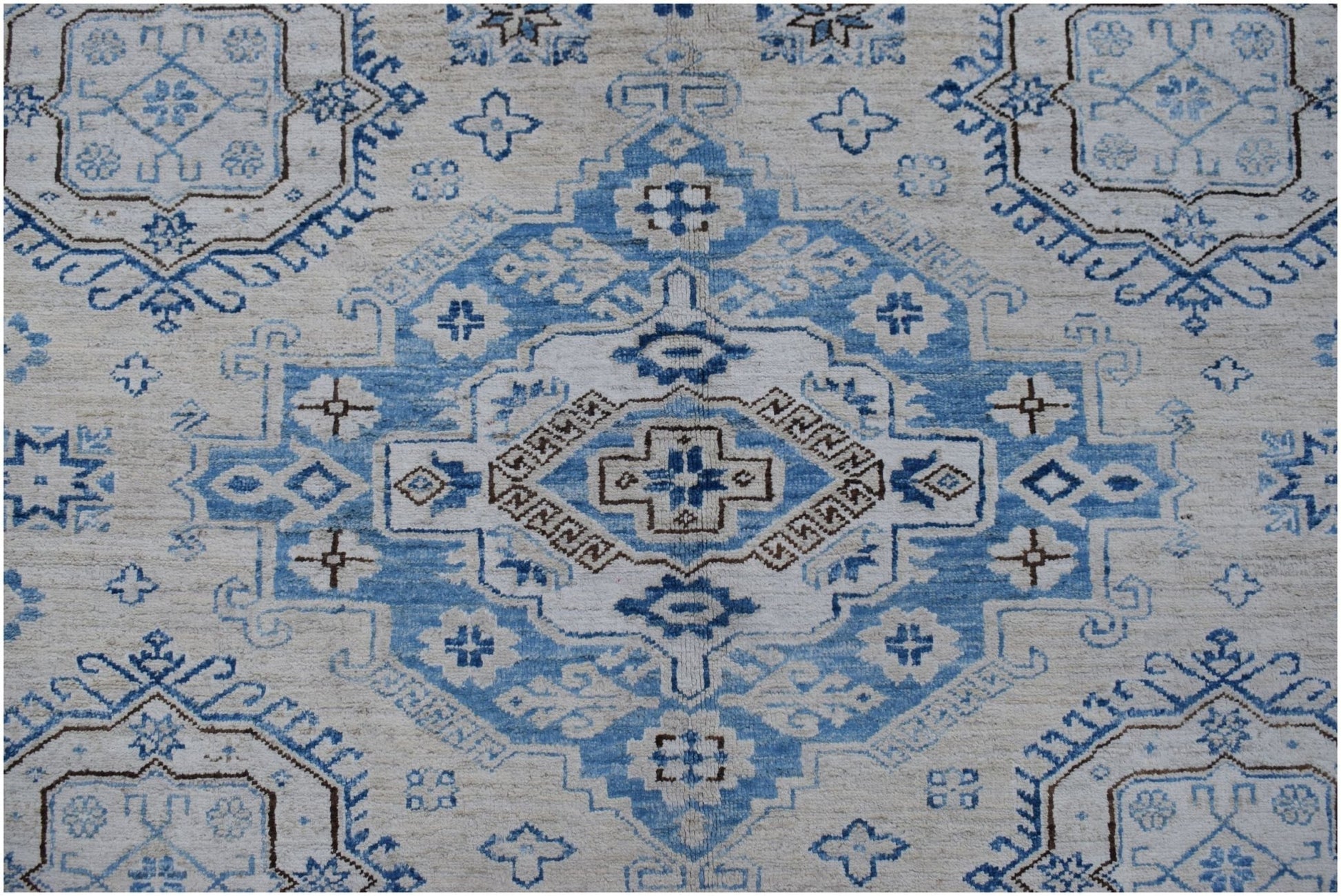 An Afghan Super Kazakh rug featuring a traditional blue and cream geometric medallion pattern.