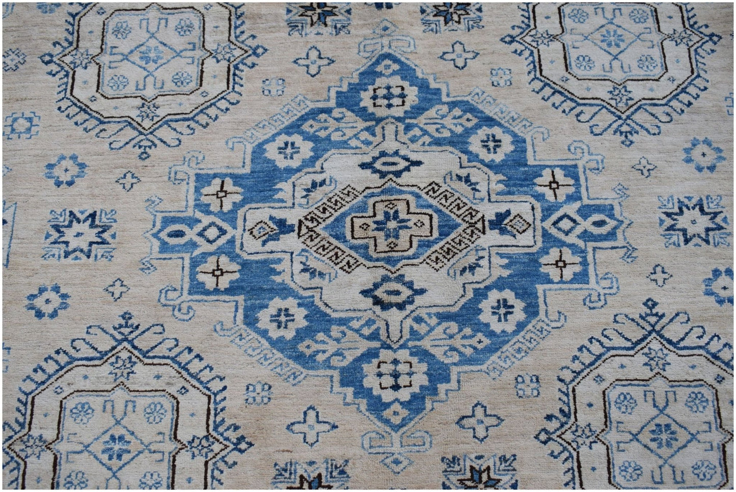 Handmade Afghan Super Kazakh rug featuring a traditional blue and cream geometric medallion pattern.