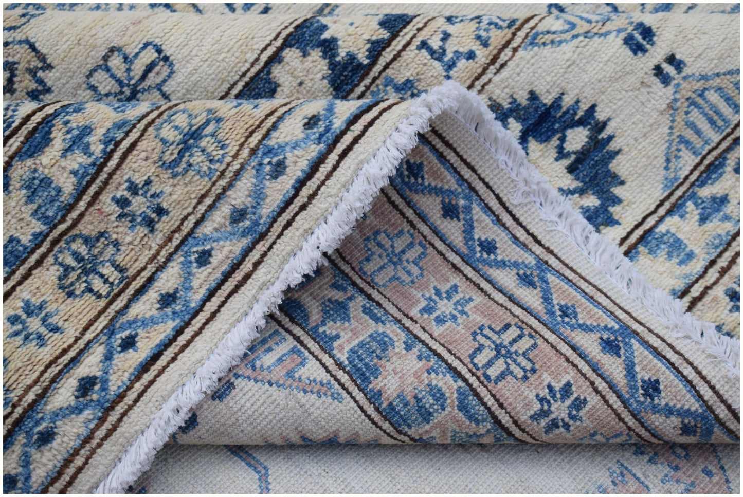 A handmade Afghan Super Kazakh rug featuring traditional blue and cream geometric patterns.